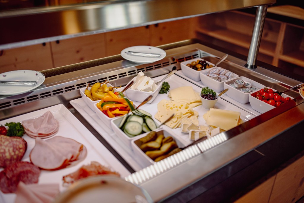 Aufgeschnittenes Gemüse, Schinken, Wurst- und Käsespezialitäten am Frühstücksbuffet