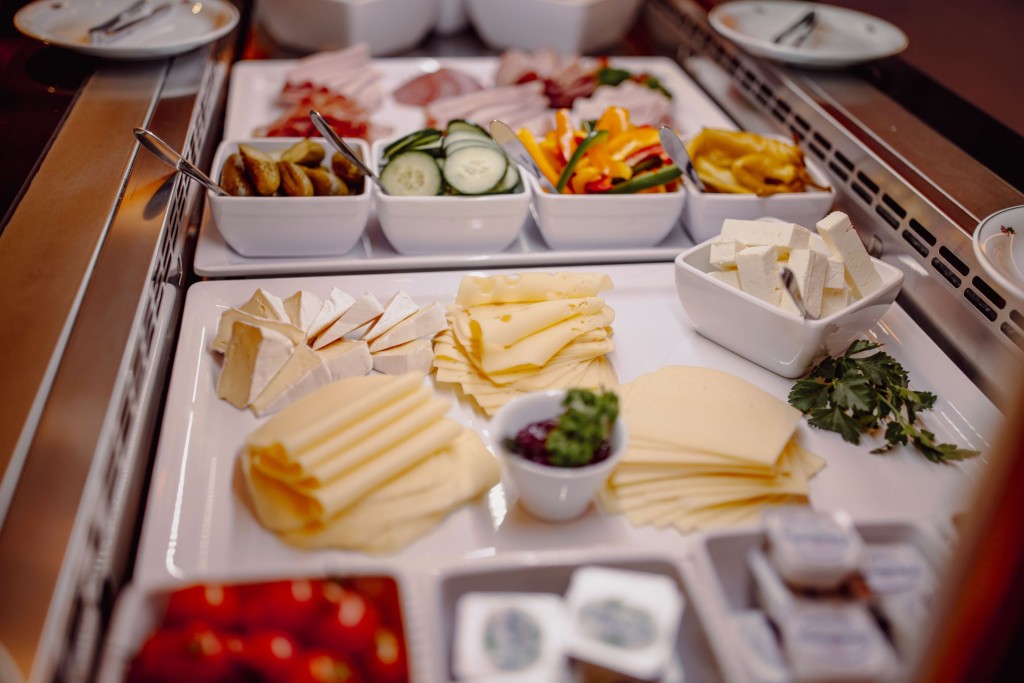 Aufgeschnittenes Gemüse, Schinken, Wurst- und Käsespezialitäten am Frühstücksbuffet